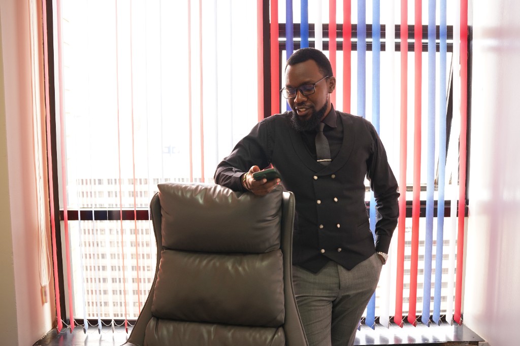 Professional team member in business attire reviewing a phone in a bright modern office